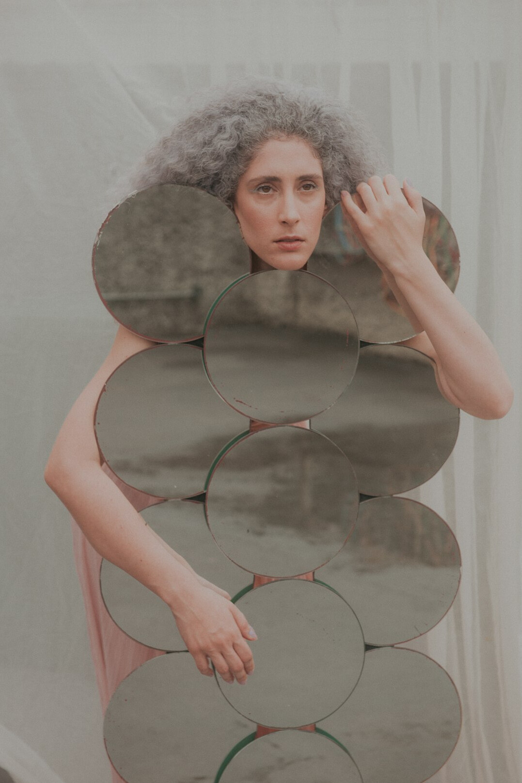 Brazilian woman looking thoughtfully at her reflection in a mirror