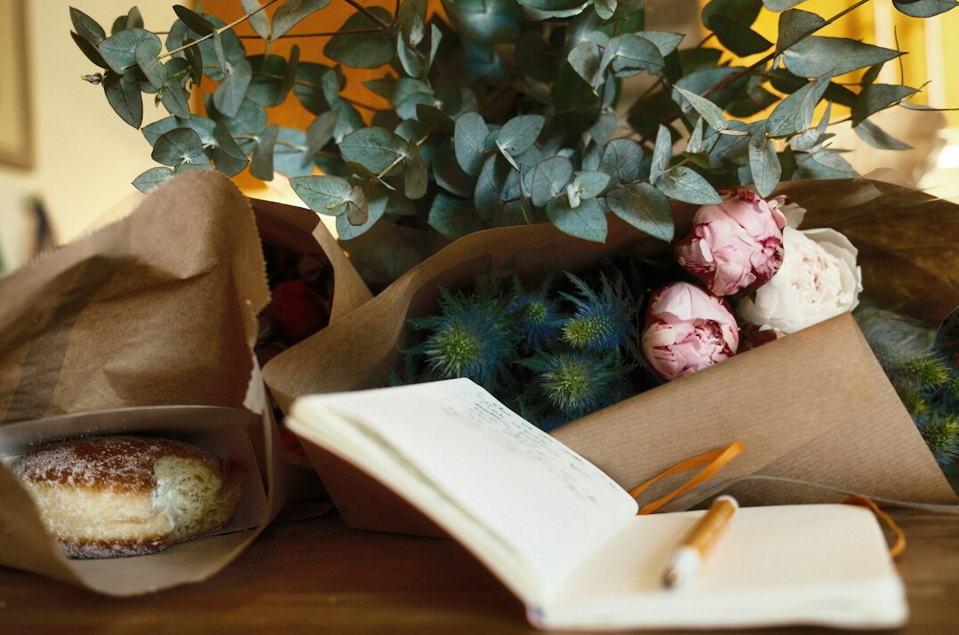 Stack of open notebooks with handwritten notes on a wooden table